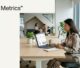 Strategist viewing a laptop dashboard with visibility metrics and search-result cards in a bright office.