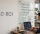 Malaysian business owner reviewing SEO analytics beside a funnel board labeled SEO ROI.