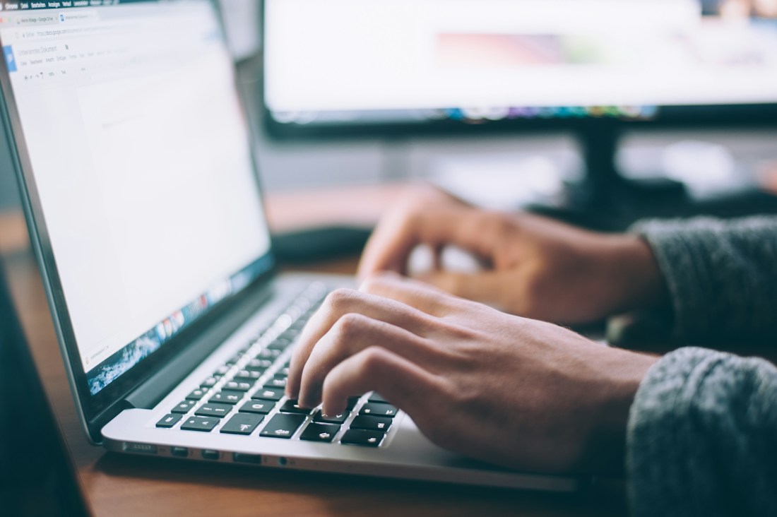 Person checking website information on laptop before preparing an AI SEO audit report